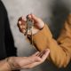 Two adults exchanging house keys, symbolic of property transfer or rental agreement.